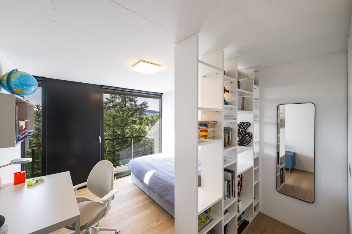 Helles Schlafzimmer mit Arbeitsplatz und großen Fenstern
