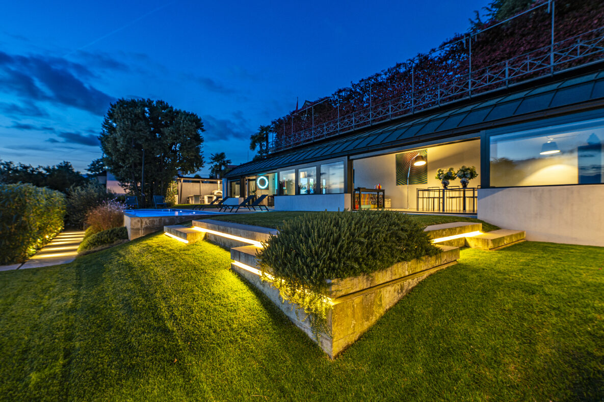 Modernes Haus mit beleuchtetem Garten bei Dämmerung