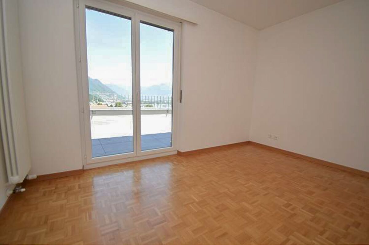 Leeres Zimmer mit Balkon- bzw. Terrassentür und Ausblick