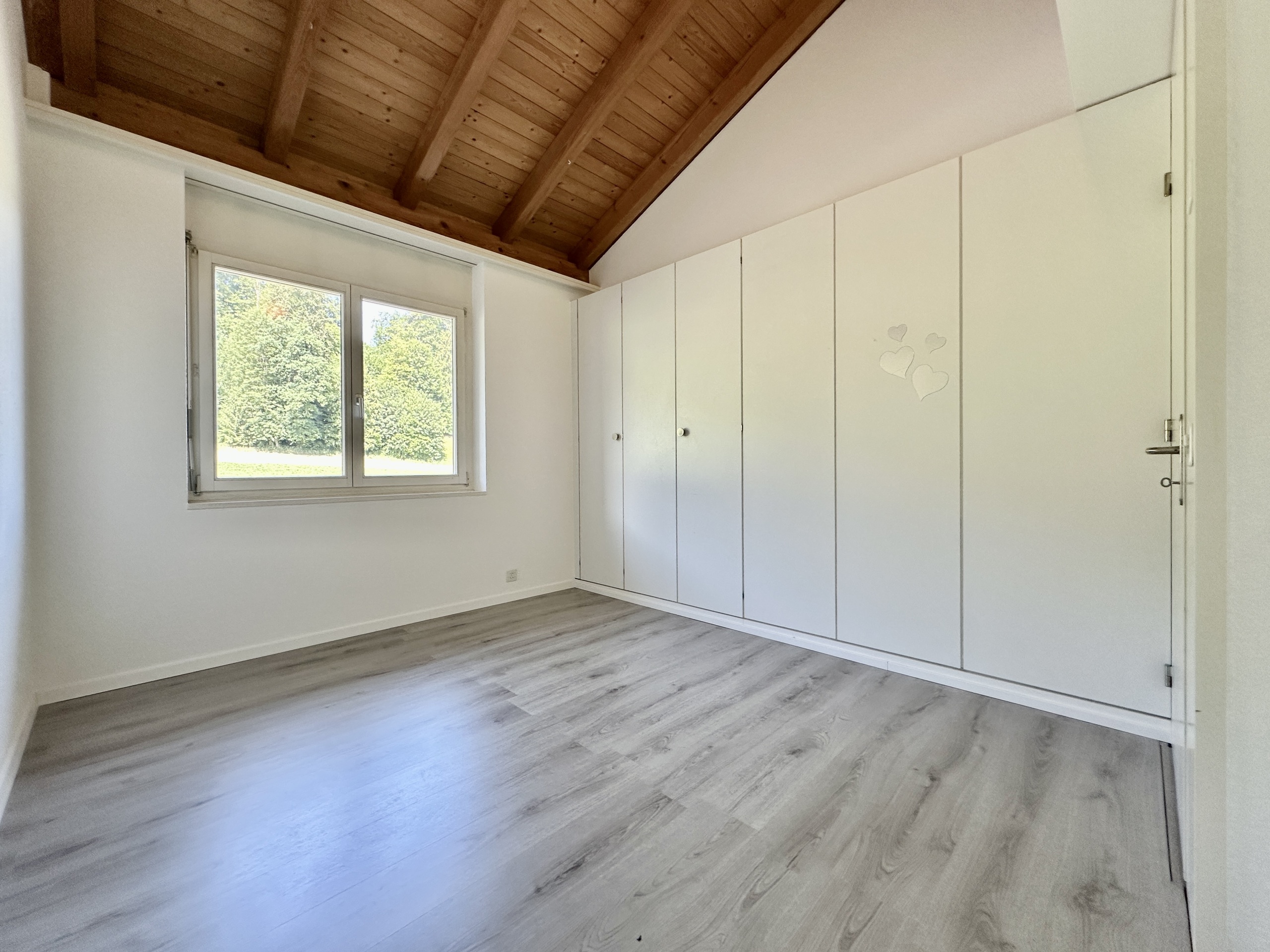 Helles Schlafzimmer mit Dachschräge und Einbauschrank