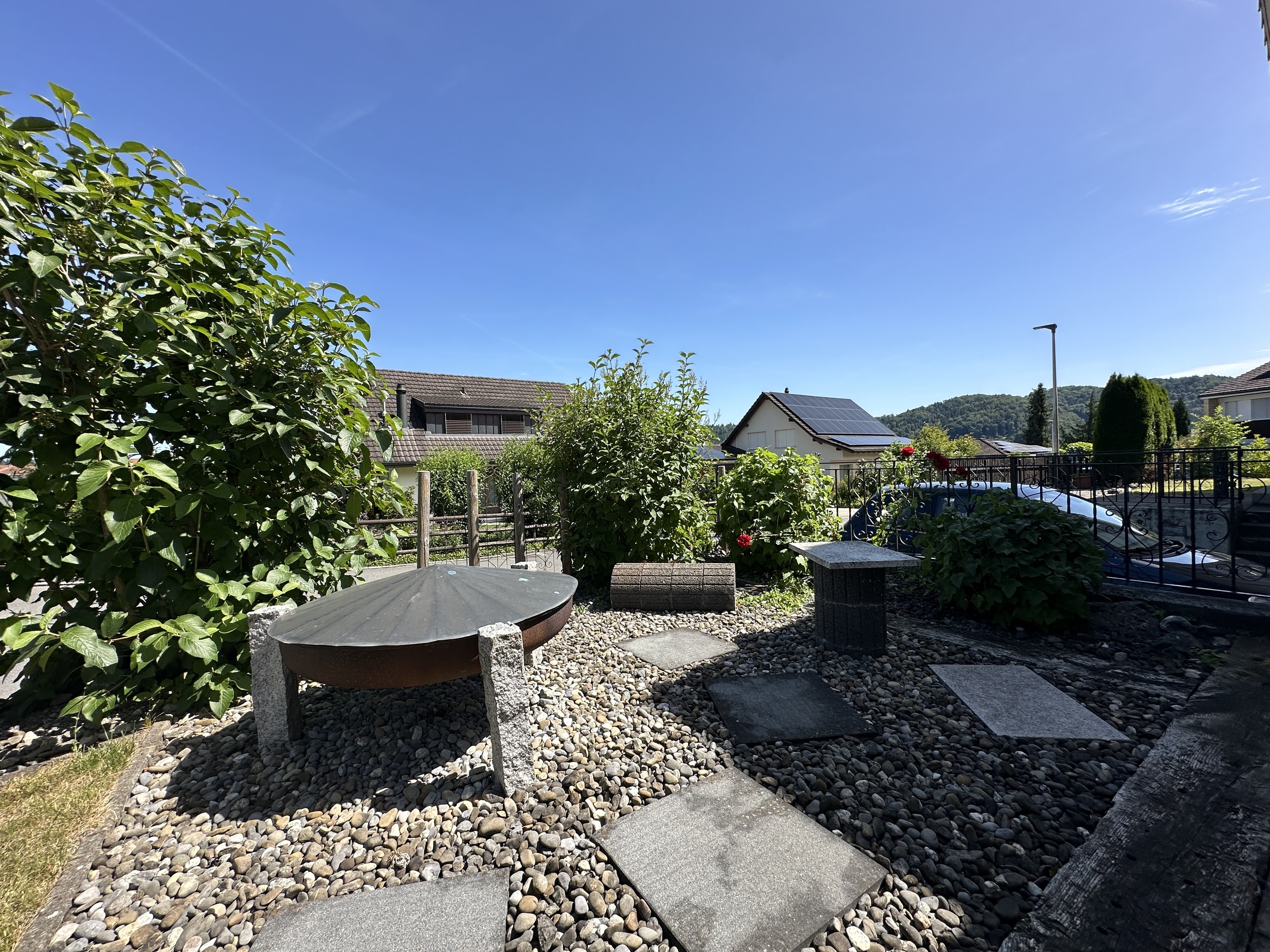 Garten mit Sitzbereich und Blick auf Wohnhäuser