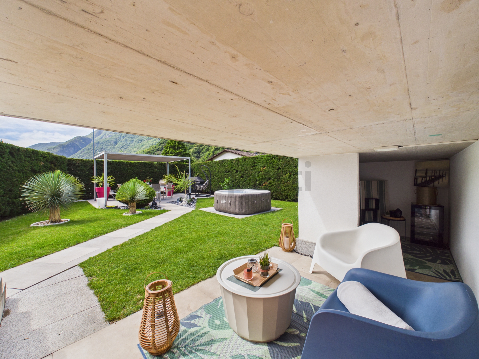 Überdachte Gartenterrasse mit Lounge und Bergblick