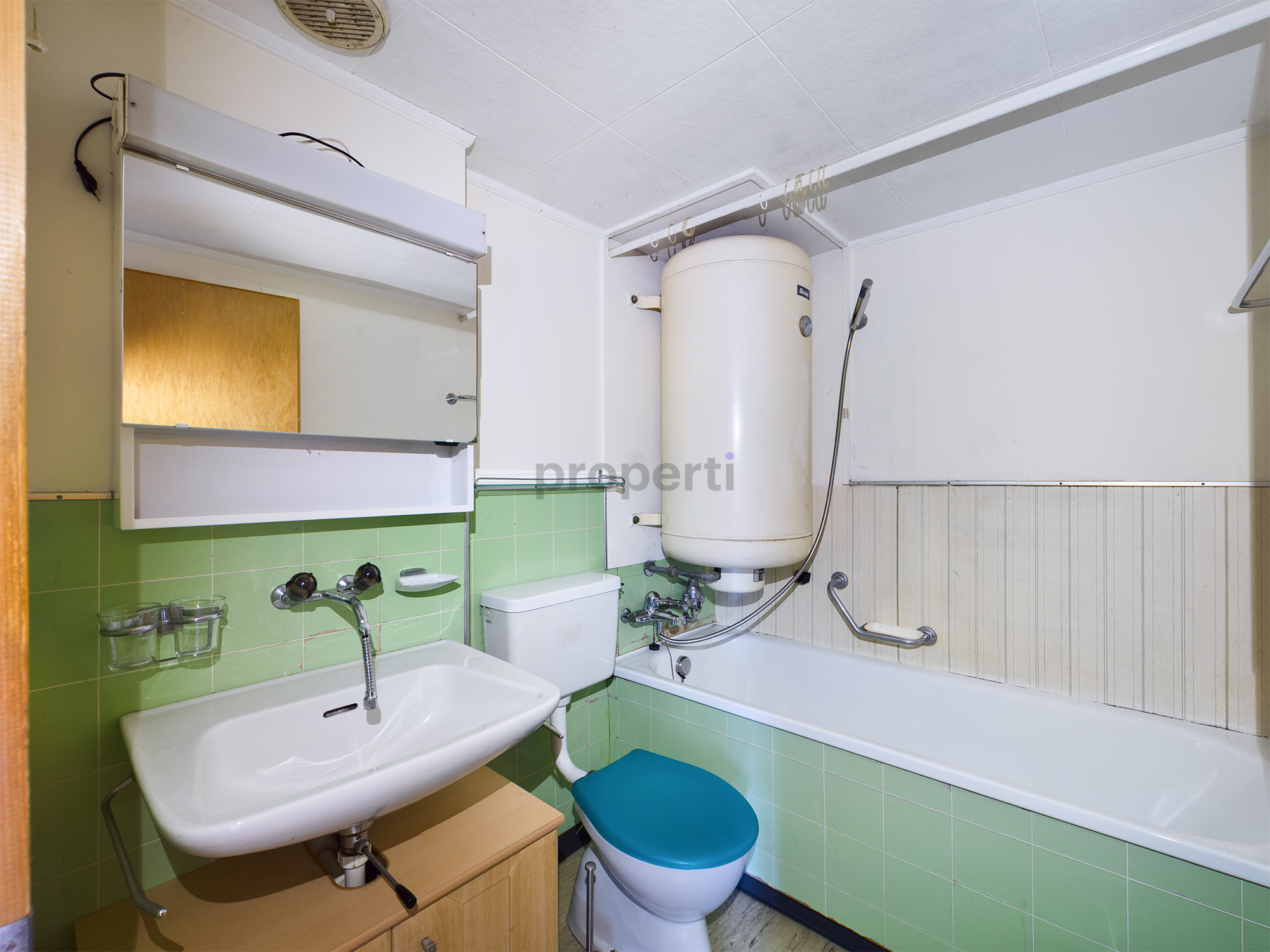 Kleines Badezimmer mit Badewanne und Waschbecken