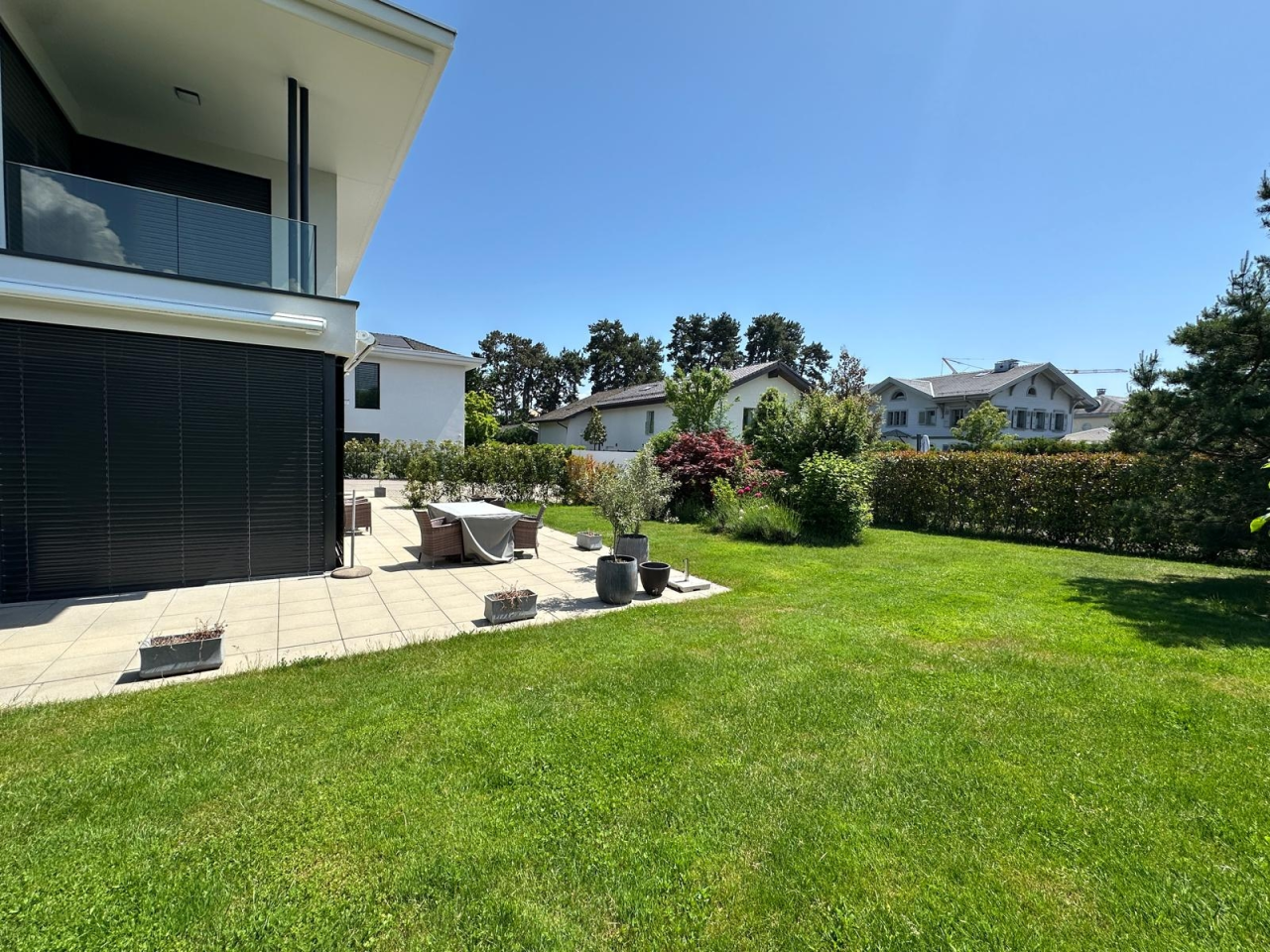 Moderner Garten mit Terrasse und Nachbarbebauung