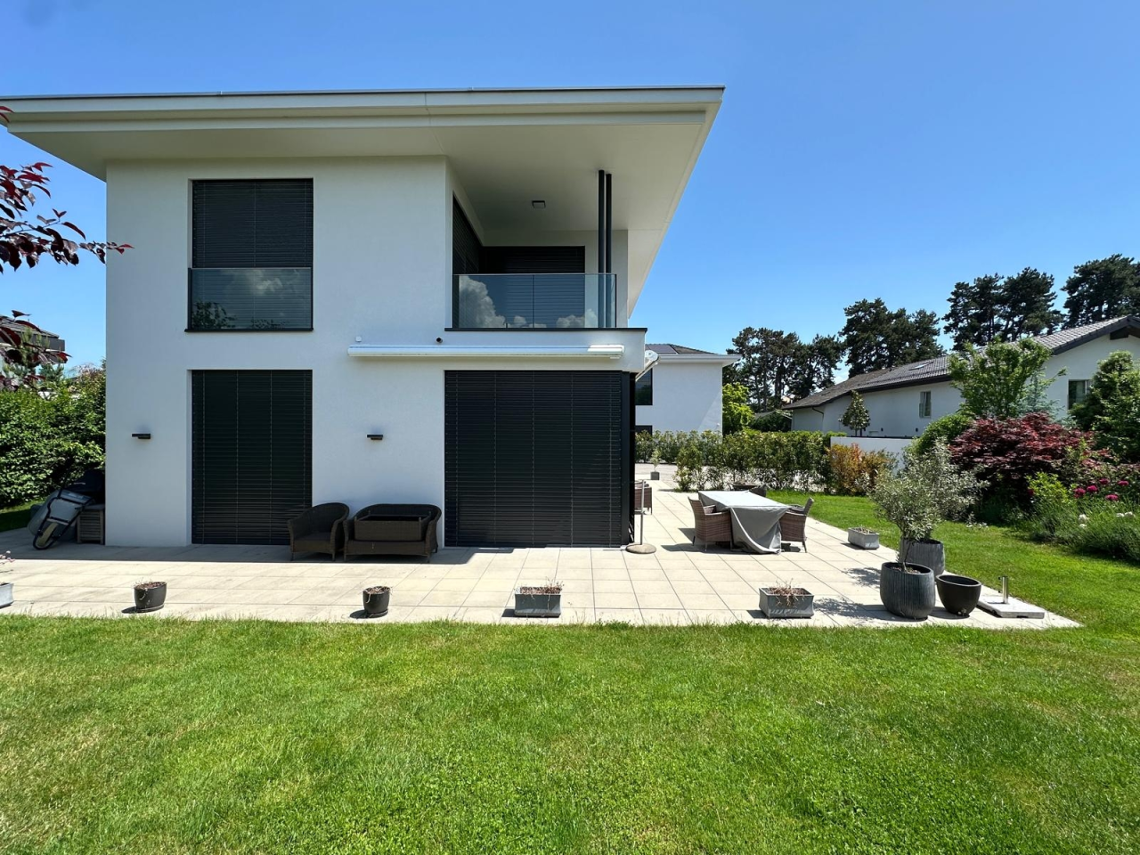 Moderne Hausfassade mit Terrasse und Garten