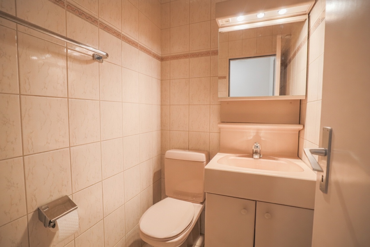 Kleines Badezimmer mit Waschbecken und WC
