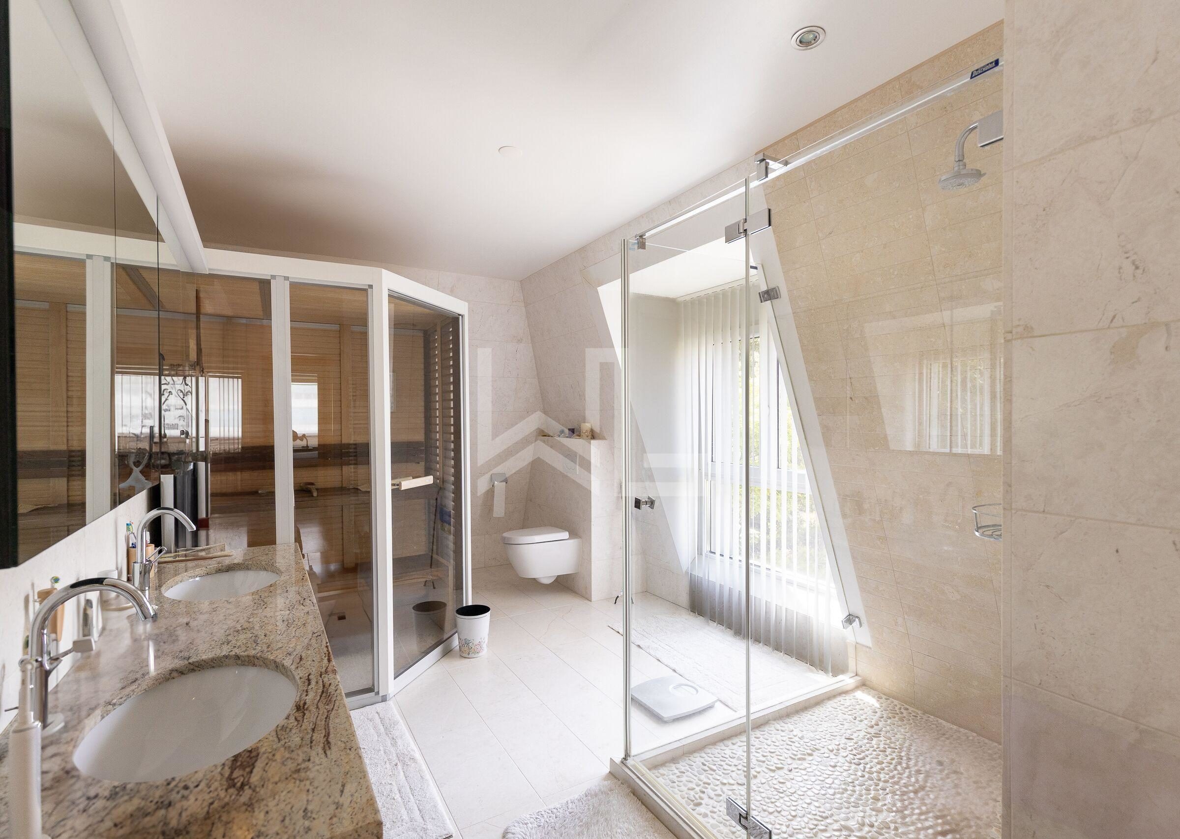 Luxuriöses Badezimmer mit Doppelwaschtisch und Glasdusche