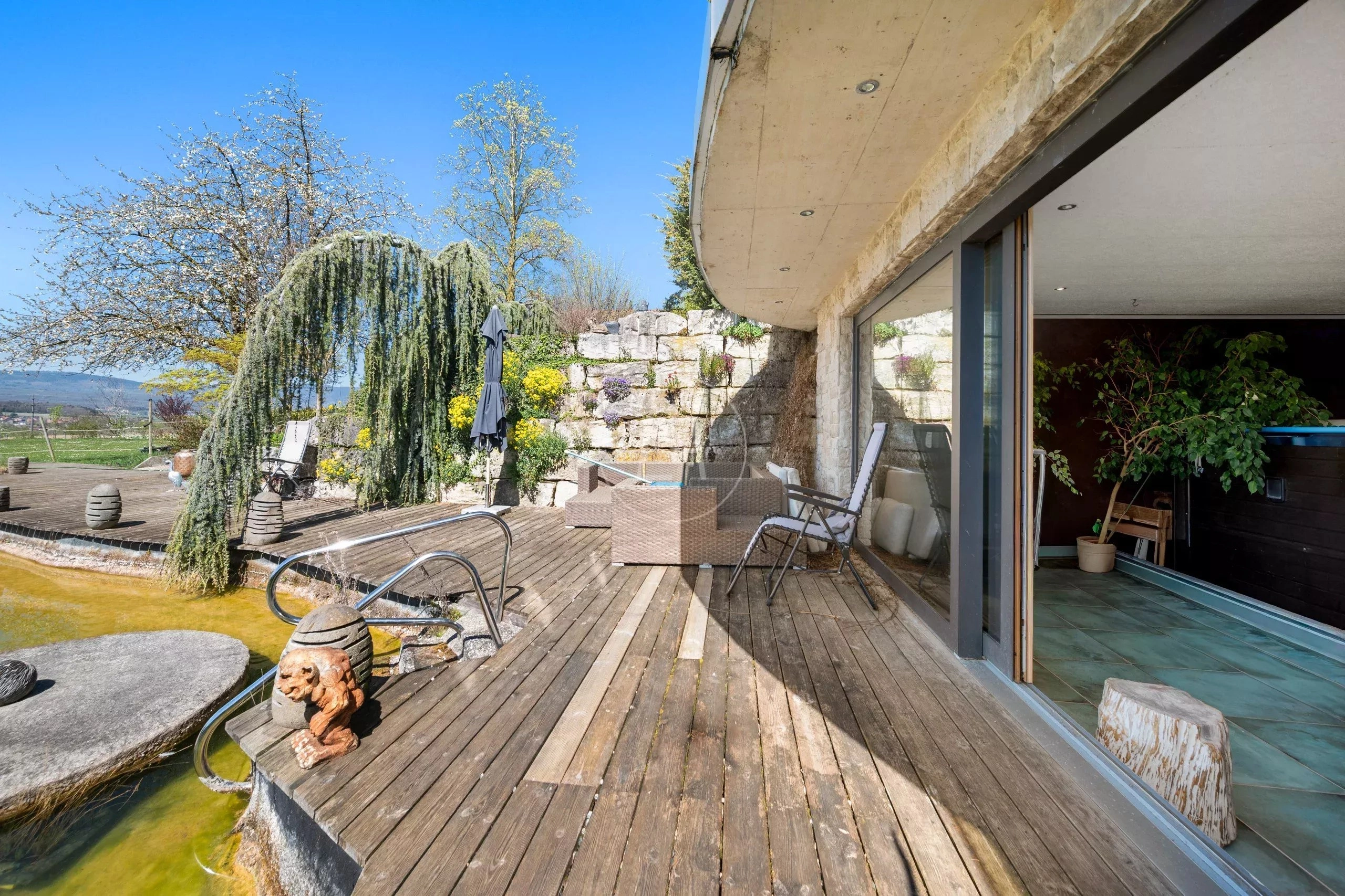 Terrasse mit Naturteich und Gartenlounge
