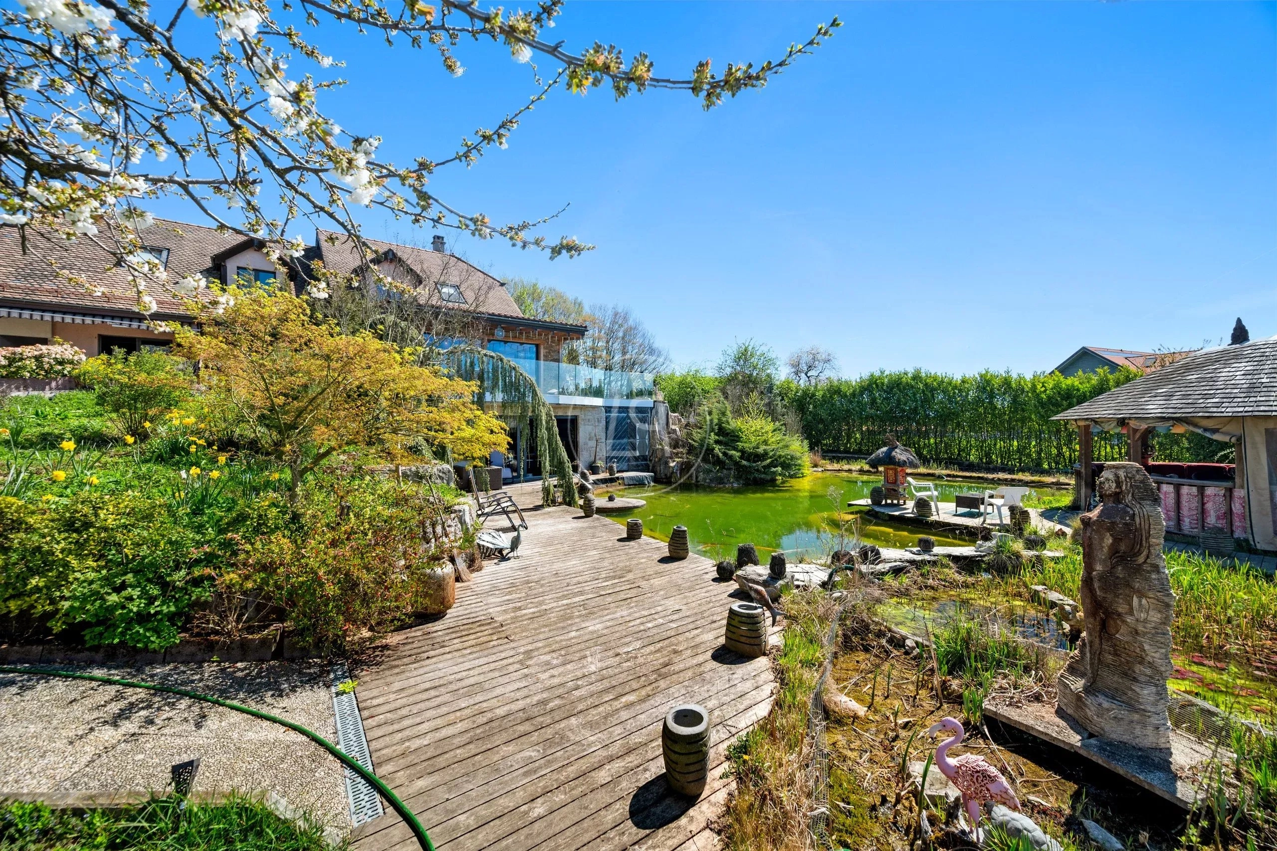 Großer Garten mit Teich, Holzdeck und Haus