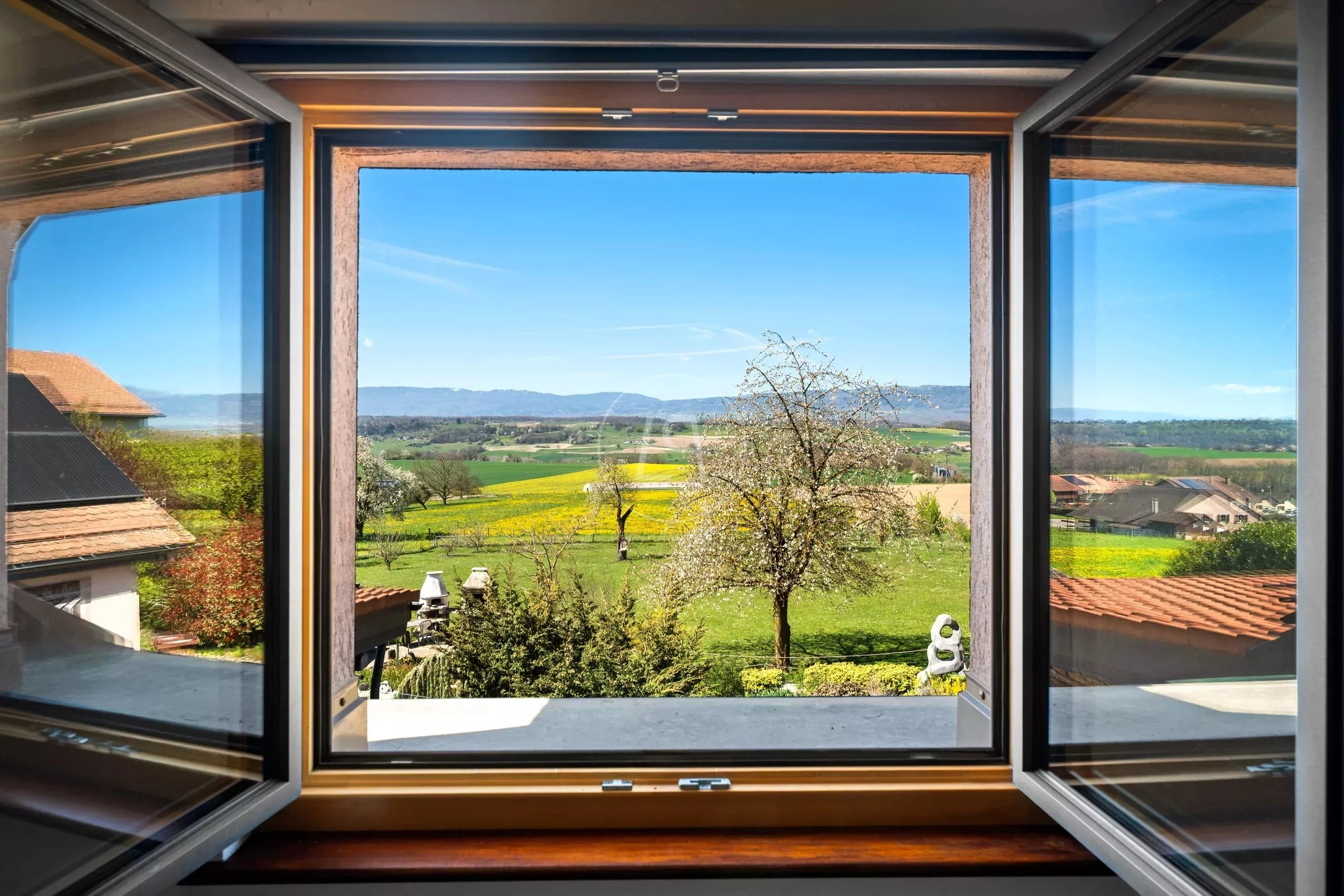 Blick aus einem geöffneten Fenster in die Landschaft