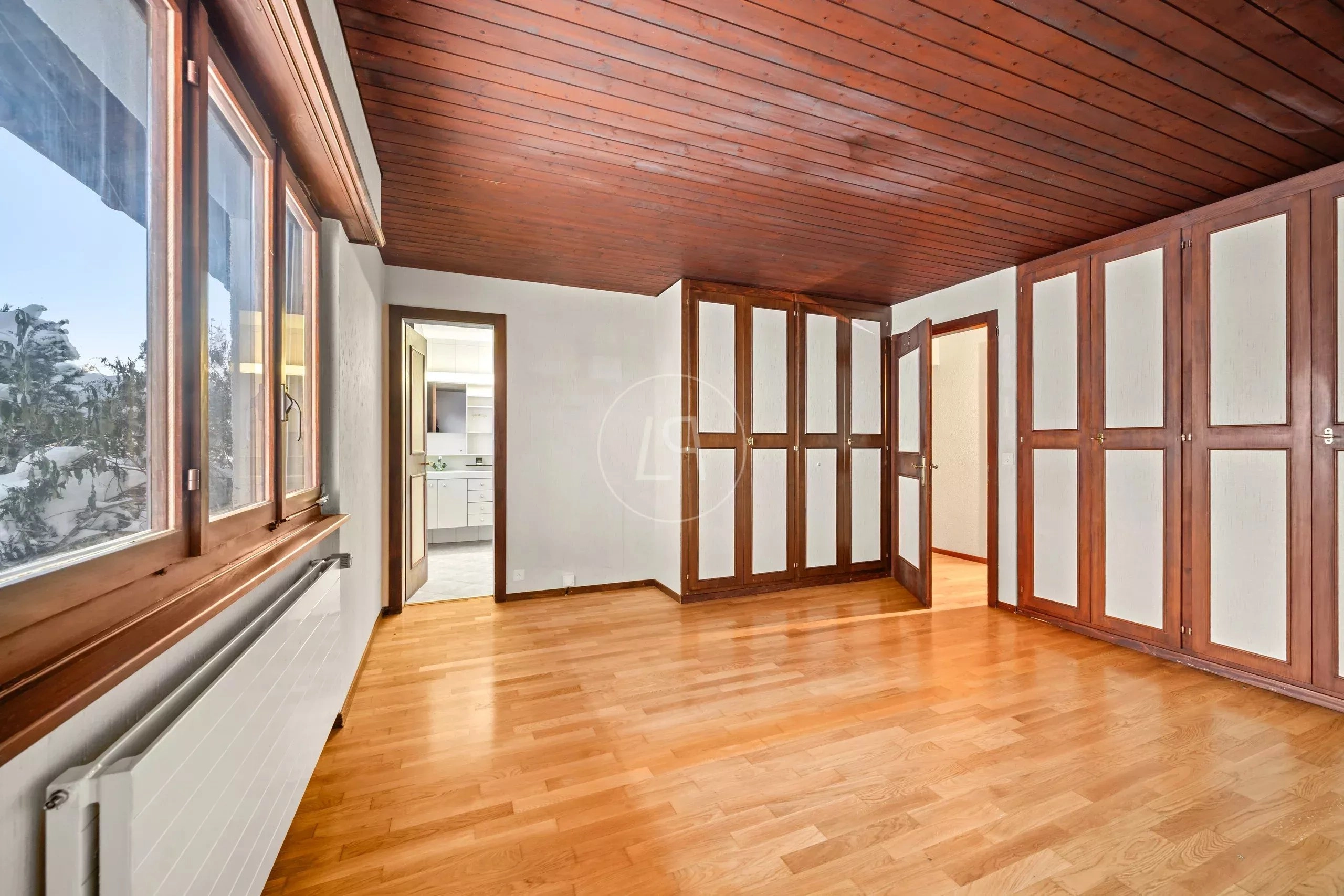 Heller Raum mit Holzdecken und Einbauschränken