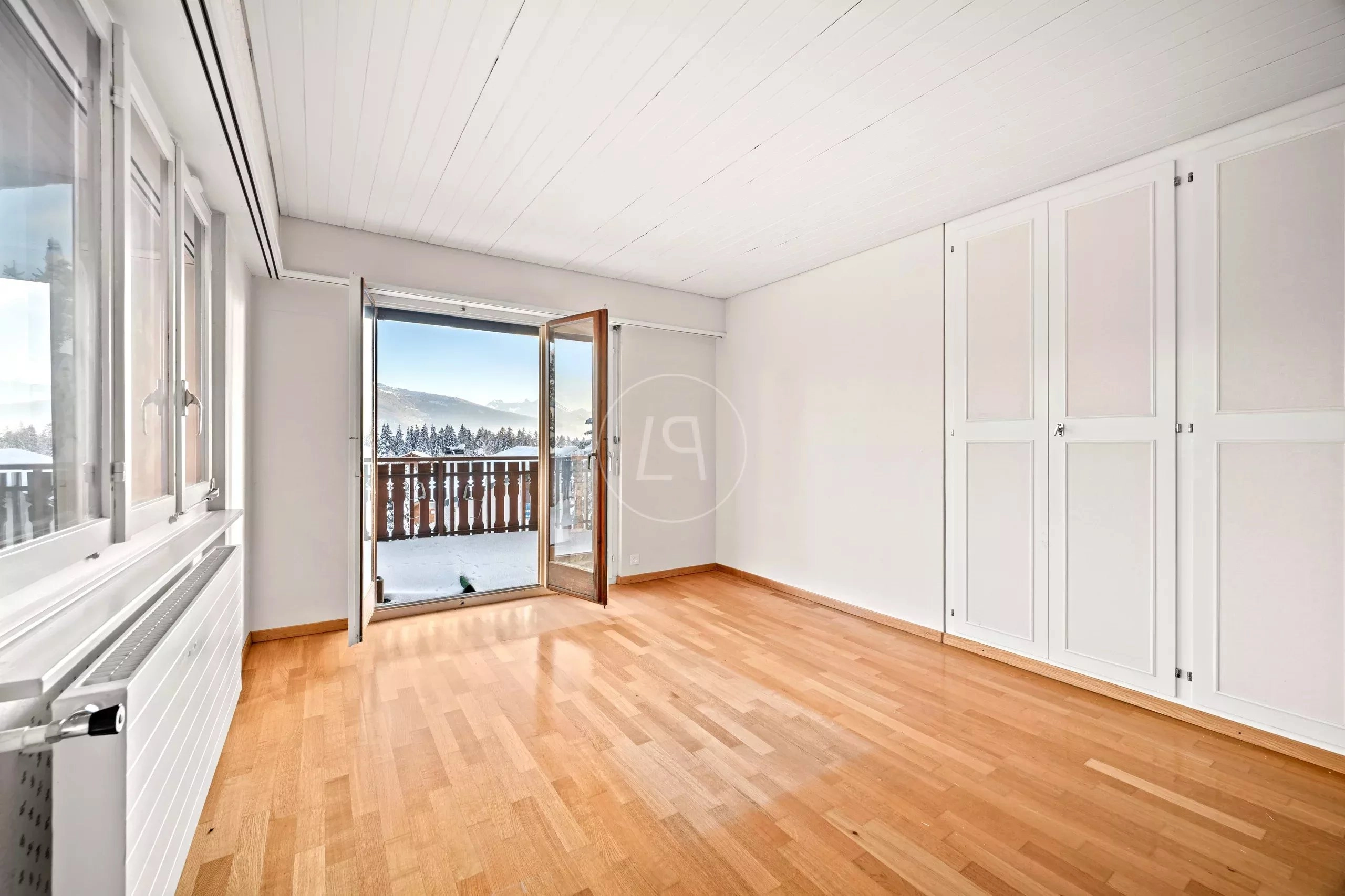 Heller leerer Raum mit Balkon und Bergblick