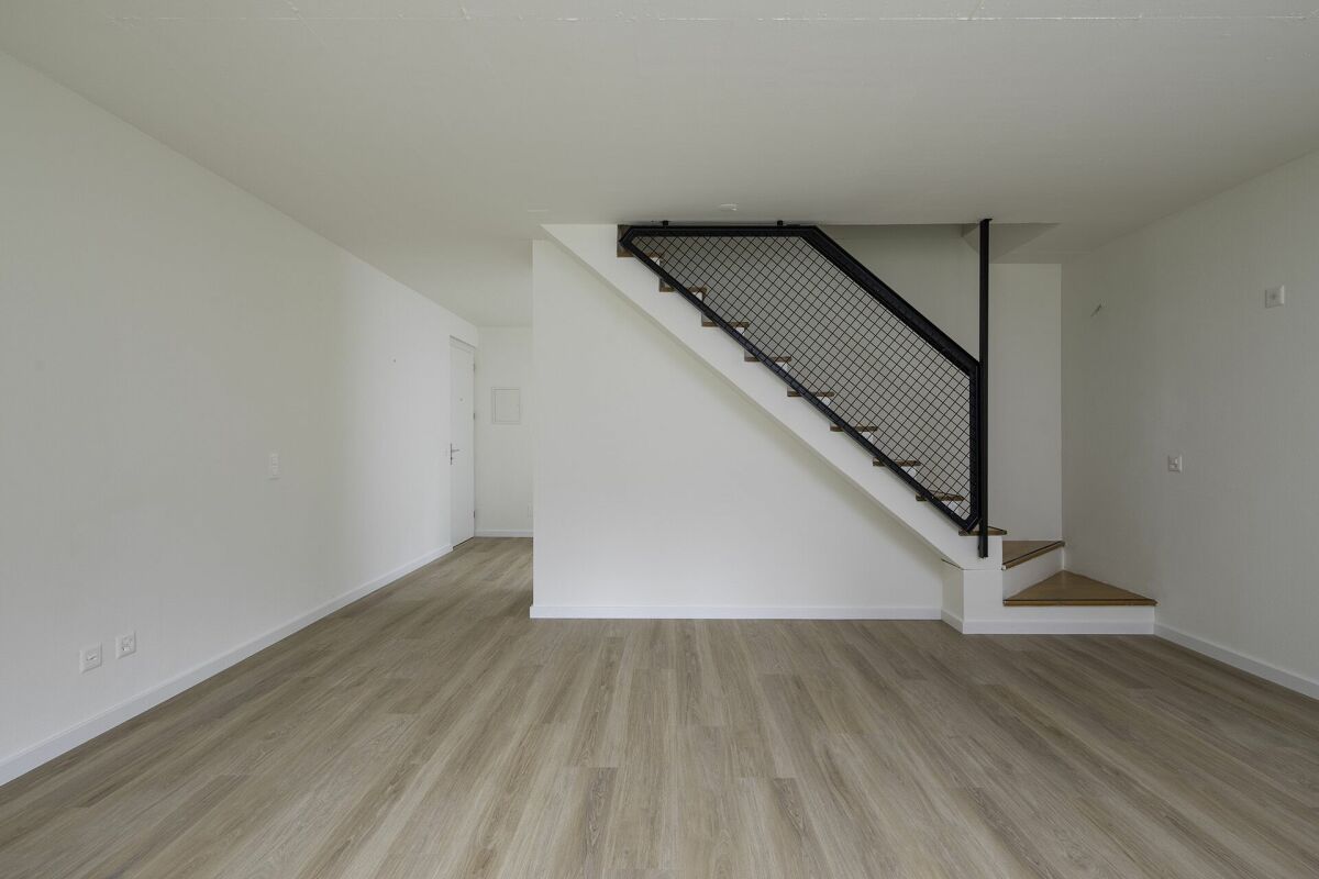 Heller, leerer Wohnraum mit Treppe