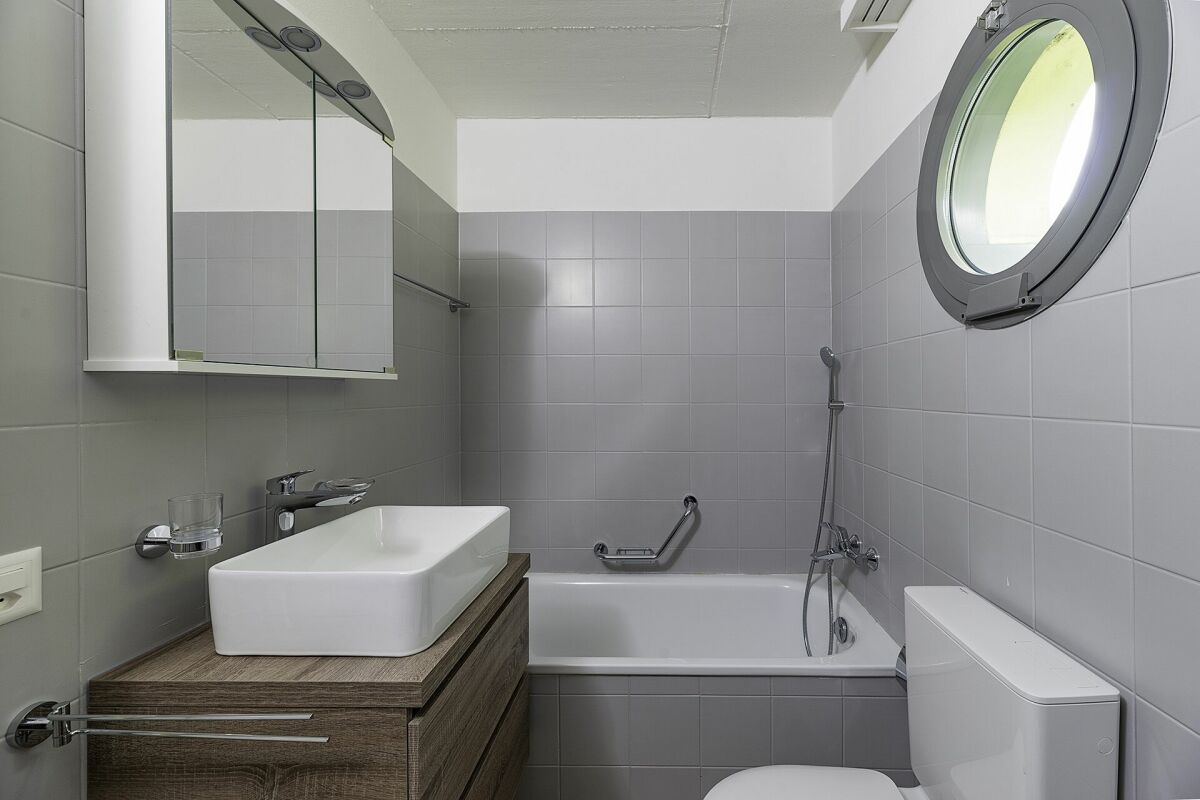Modernes Badezimmer mit Badewanne und rundem Fenster