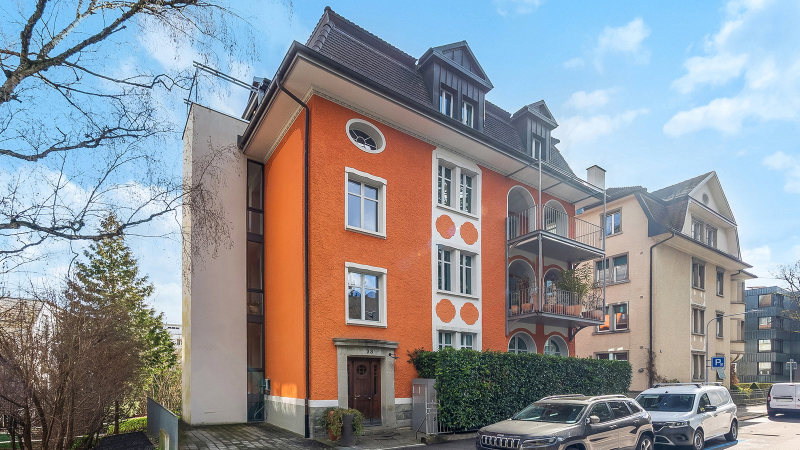 Historische Mehrfamilienhausfassade in sonniger Straßenszene