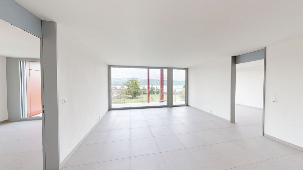 Heller, leerer Wohnraum mit großem Fenster zur Aussicht