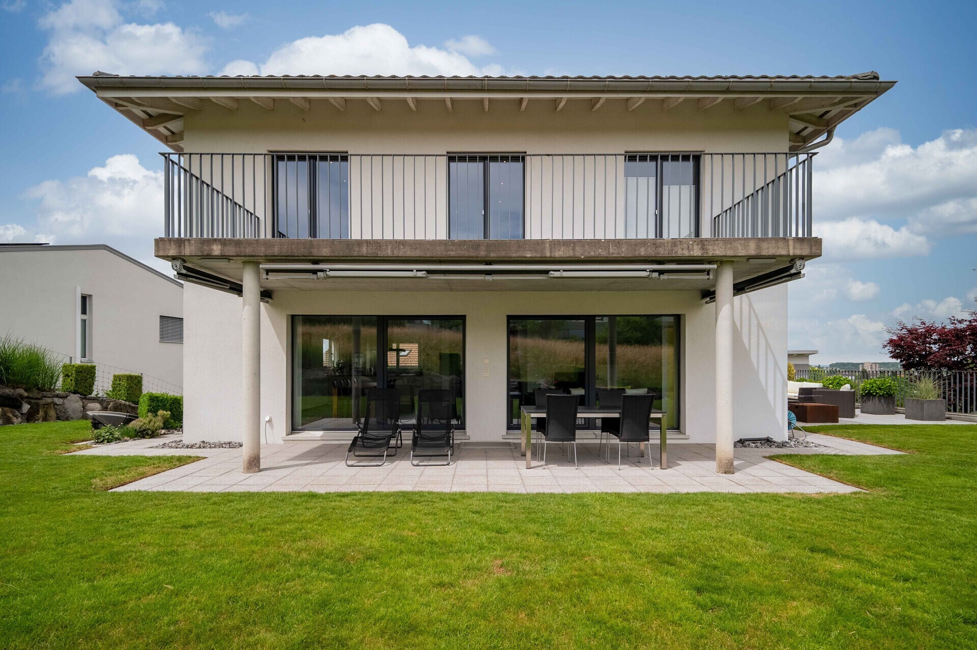 Moderne Hausfassade mit Terrasse und Balkon