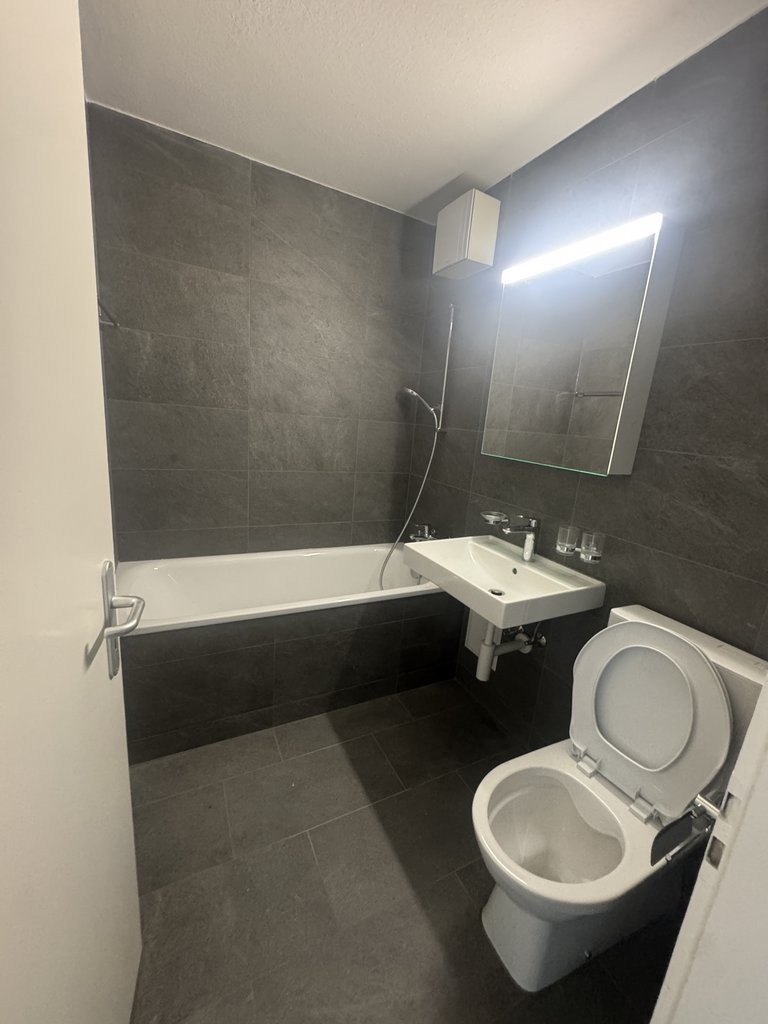 Kleines modernes Badezimmer mit Badewanne und WC