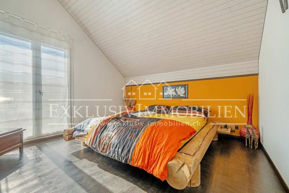 Schlafzimmer mit Dachschräge und Holzdecke