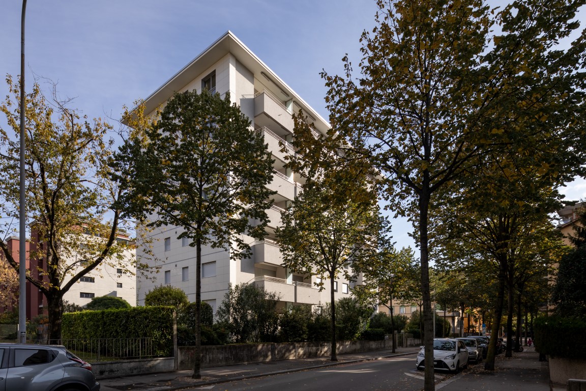 Mehrfamilienhaus an einer baumbestandenen Straße