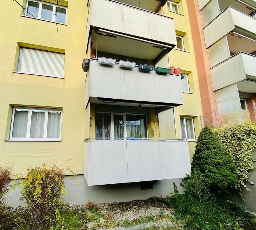 Mehrfamilienhaus mit Balkonen und begrüntem Außenbereich