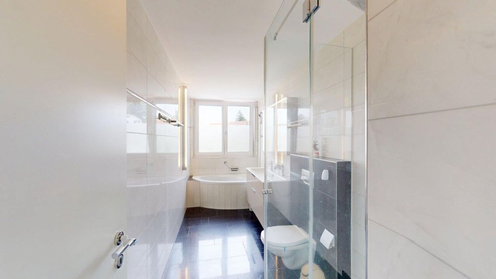 Helles Badezimmer mit Badewanne und Glasdusche