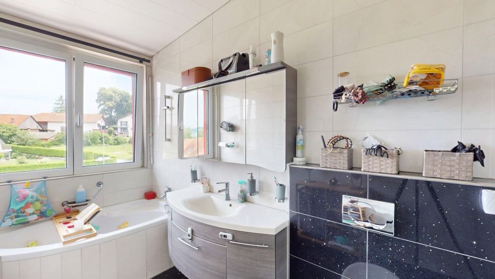 Helles Badezimmer mit Badewanne und Waschtisch