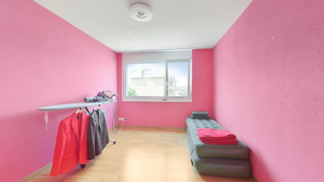 Pinkes Zimmer mit Fenster und Bügelstation
