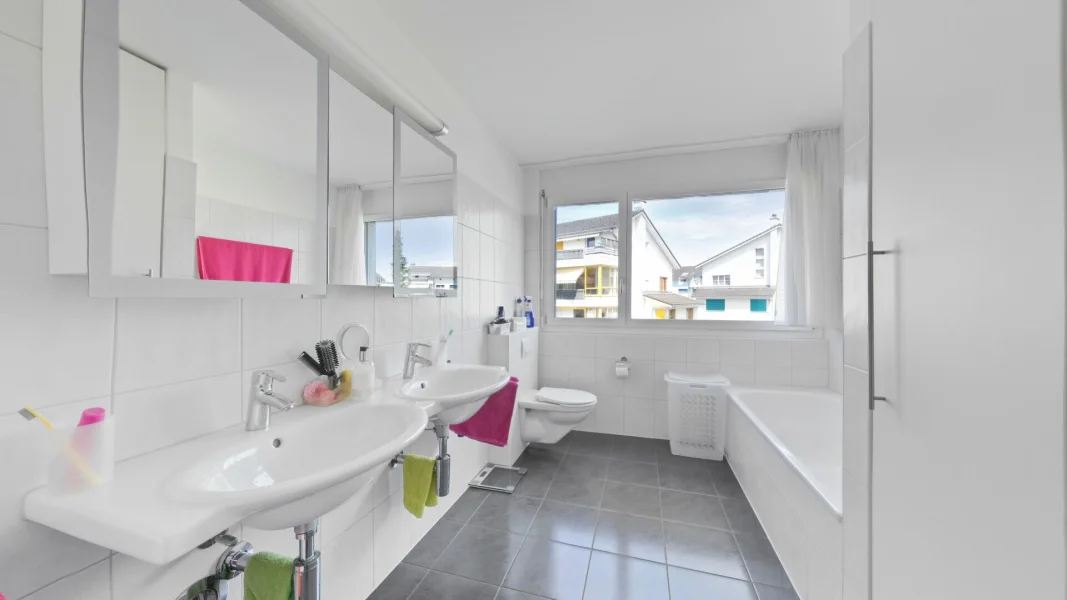 Helles Badezimmer mit Doppelwaschbecken und Badewanne