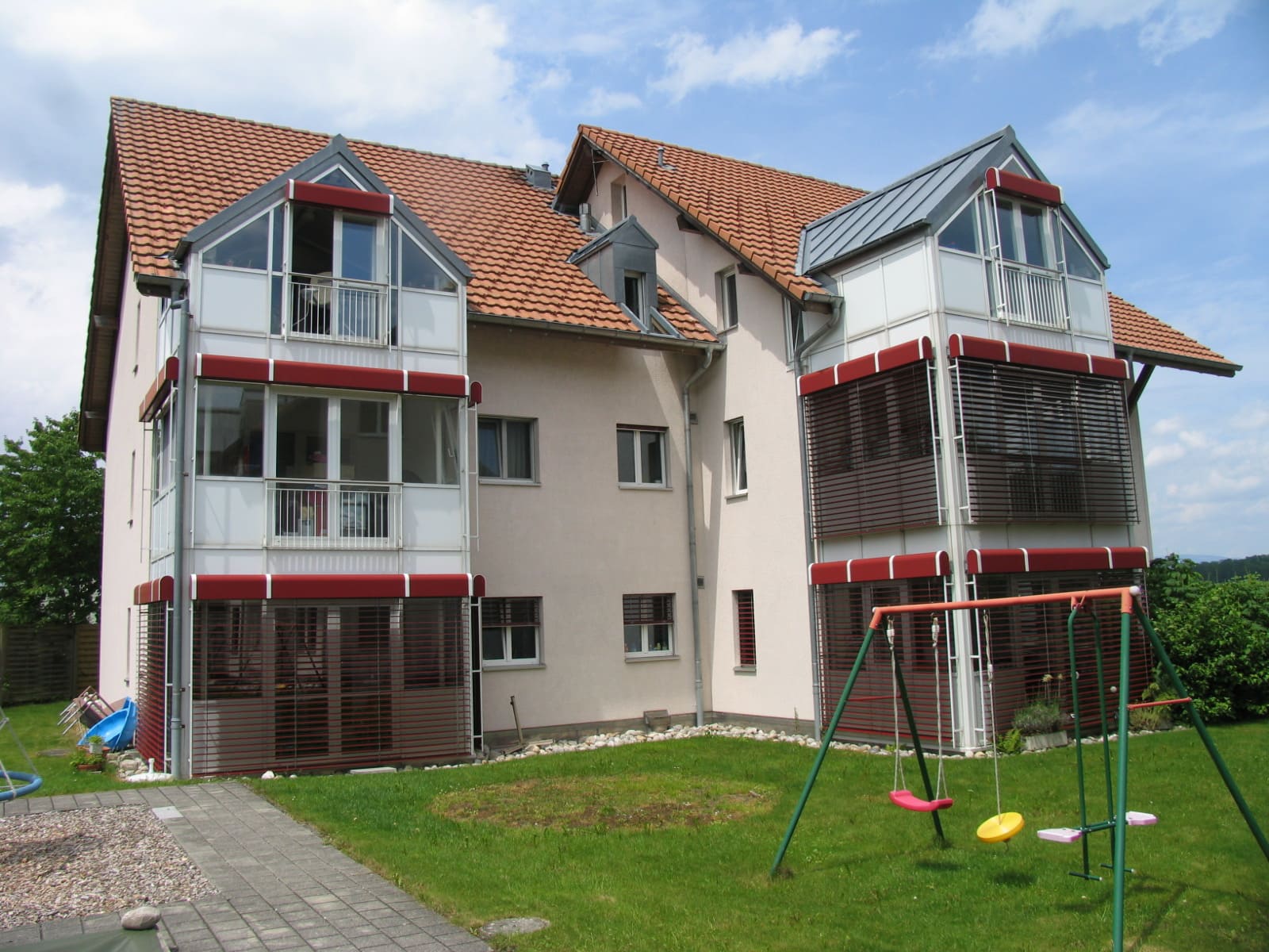 Mehrfamilienhaus mit Balkonverglasungen und Garten