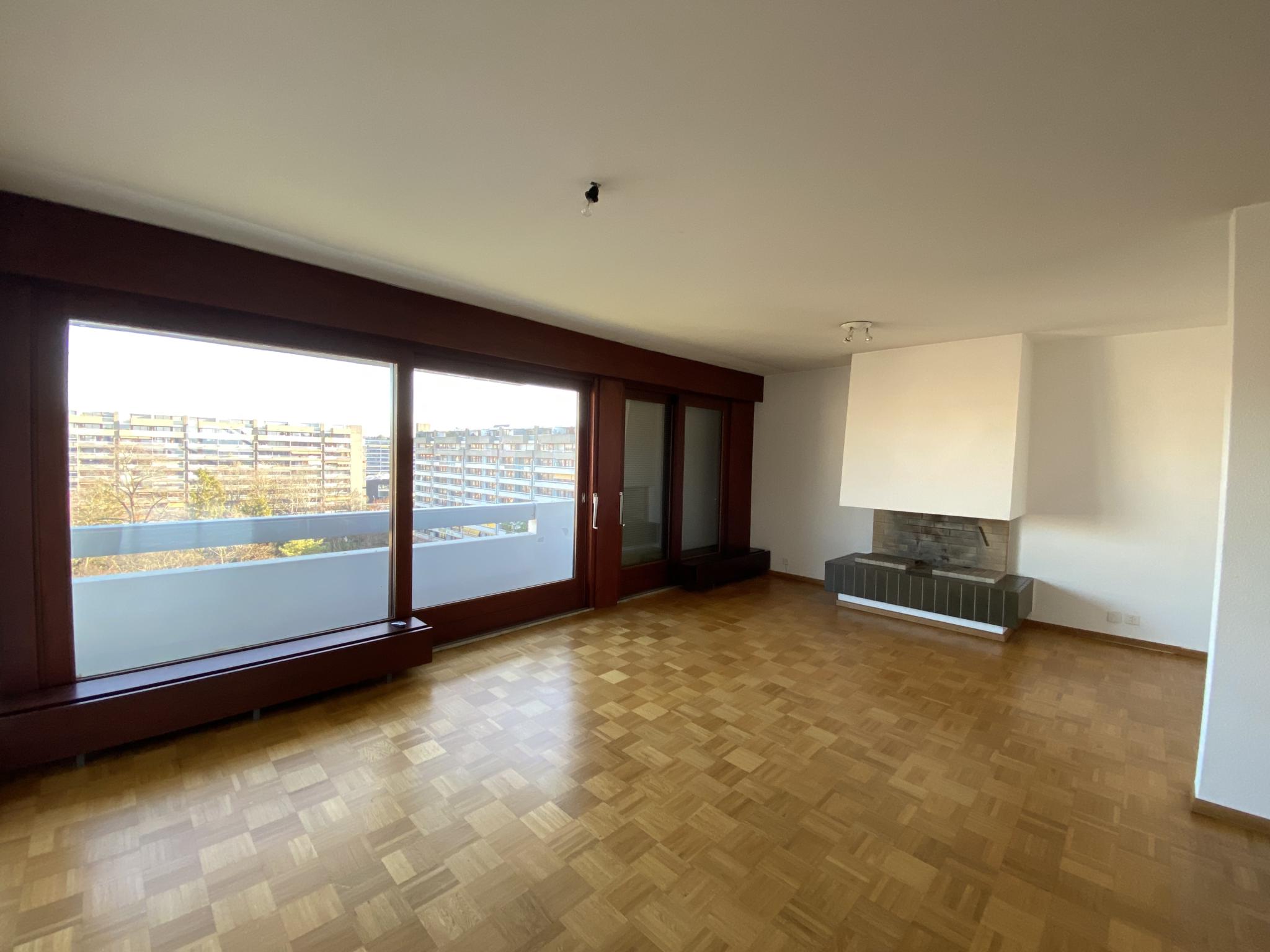 Heller Wohnraum mit großem Fensterfront und Kamin