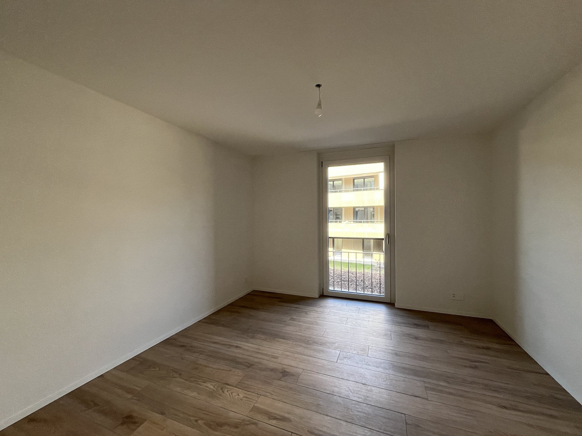 Leeres, helles Zimmer mit Balkon-/Terrassentür