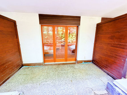 Innenraum mit Holzfenstern und Schiebeläden