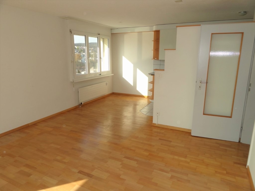 Leerer Wohnraum mit Parkett und Fenster