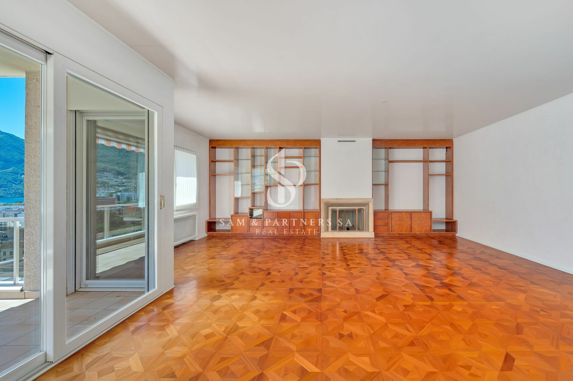 Großzügiges Wohnzimmer mit Kamin und Balkonblick