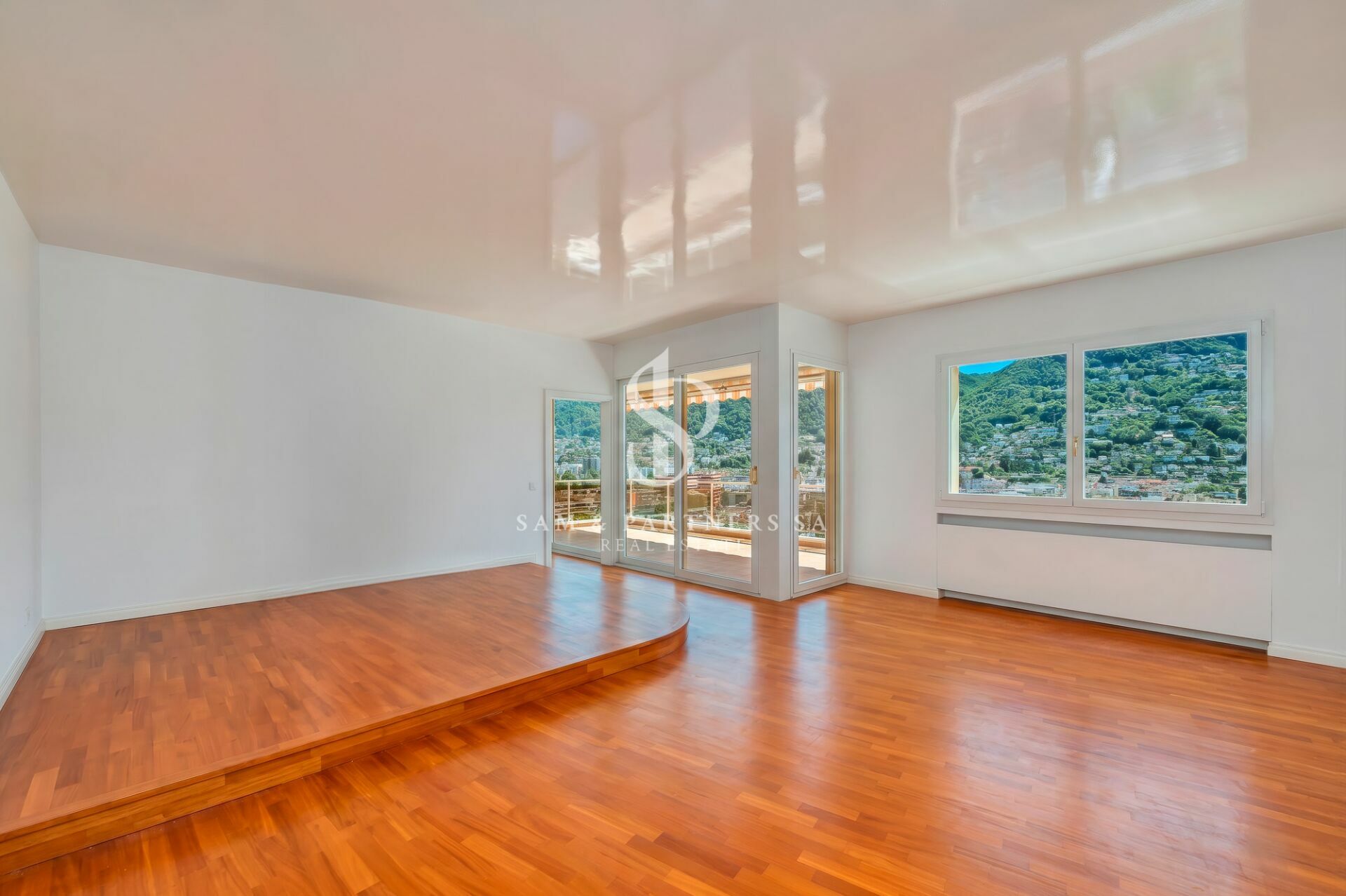 Heller leerer Wohnraum mit Holzfußboden und großem Ausblick