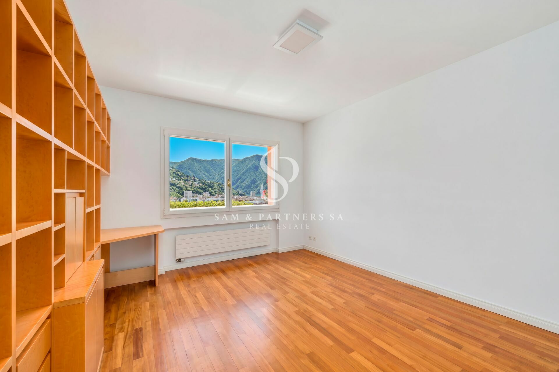 Helles leeres Zimmer mit Holzregal und Bergblick