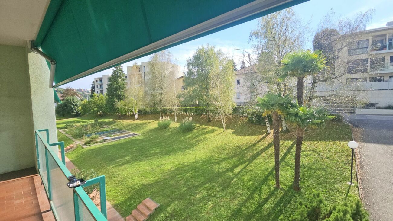 Balkon mit Blick in eine grüne Wohnanlage