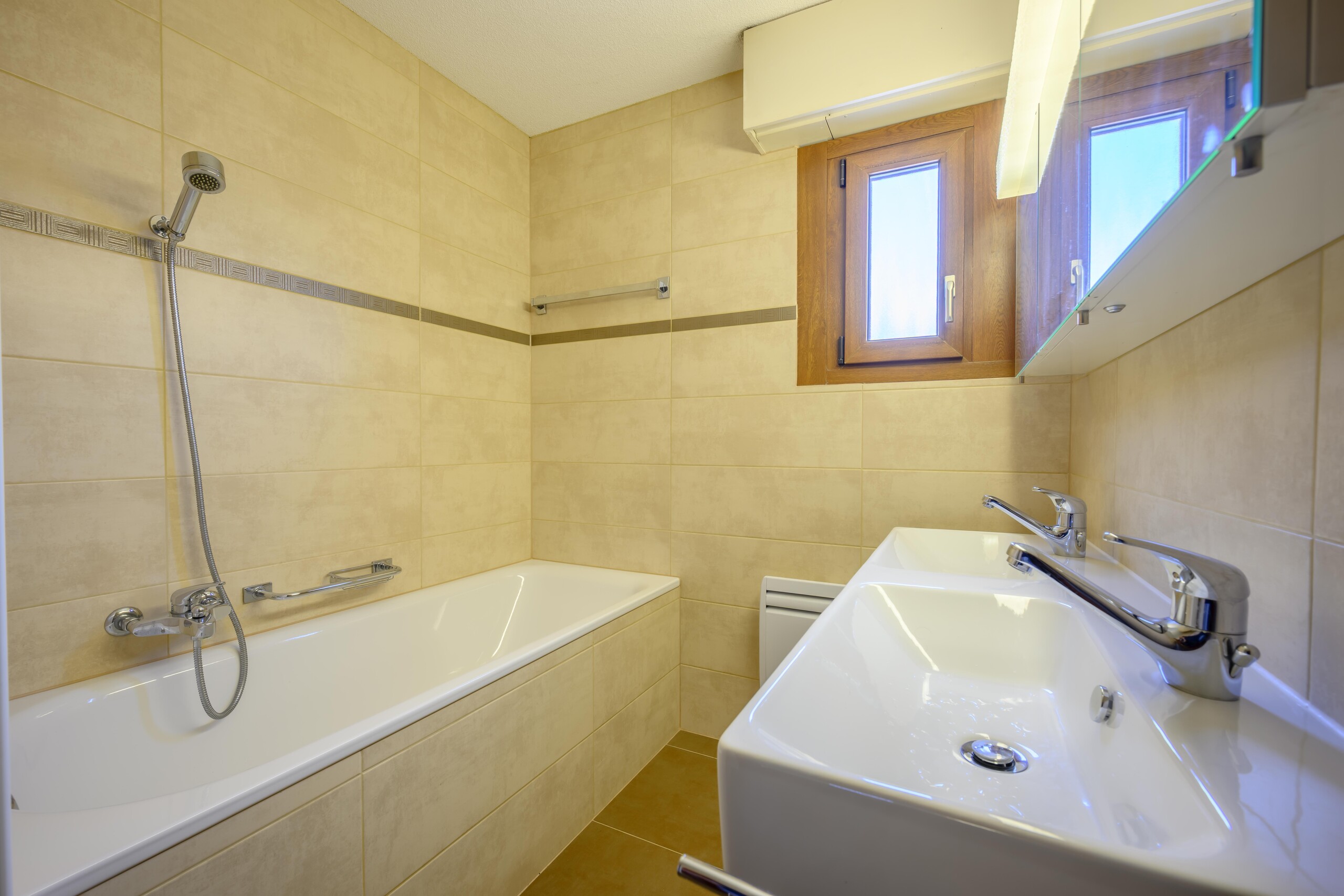 Beiges Badezimmer mit Wanne und Doppelwaschtisch