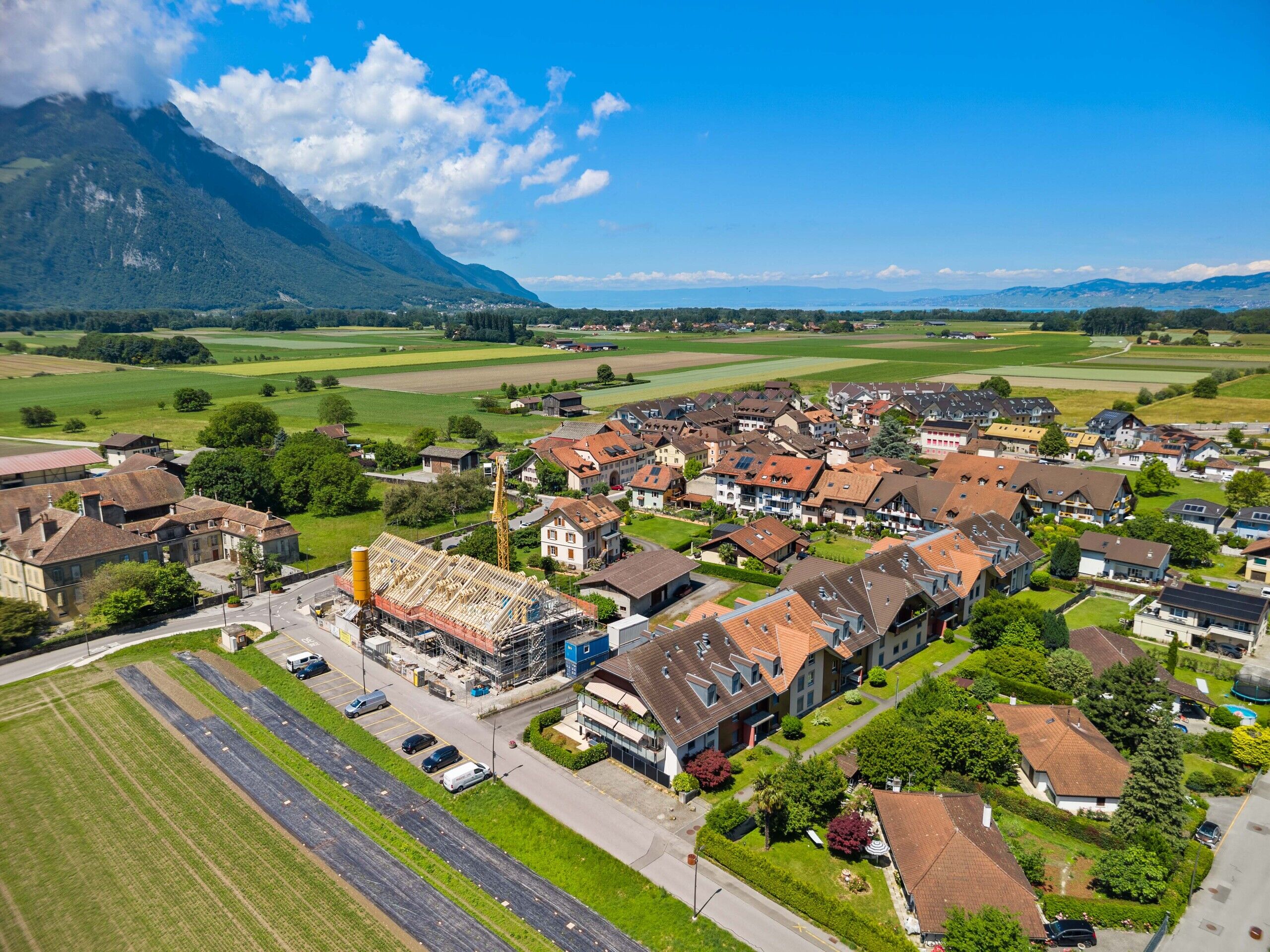 Luftaufnahme einer Wohnsiedlung am See mit Bergpanorama