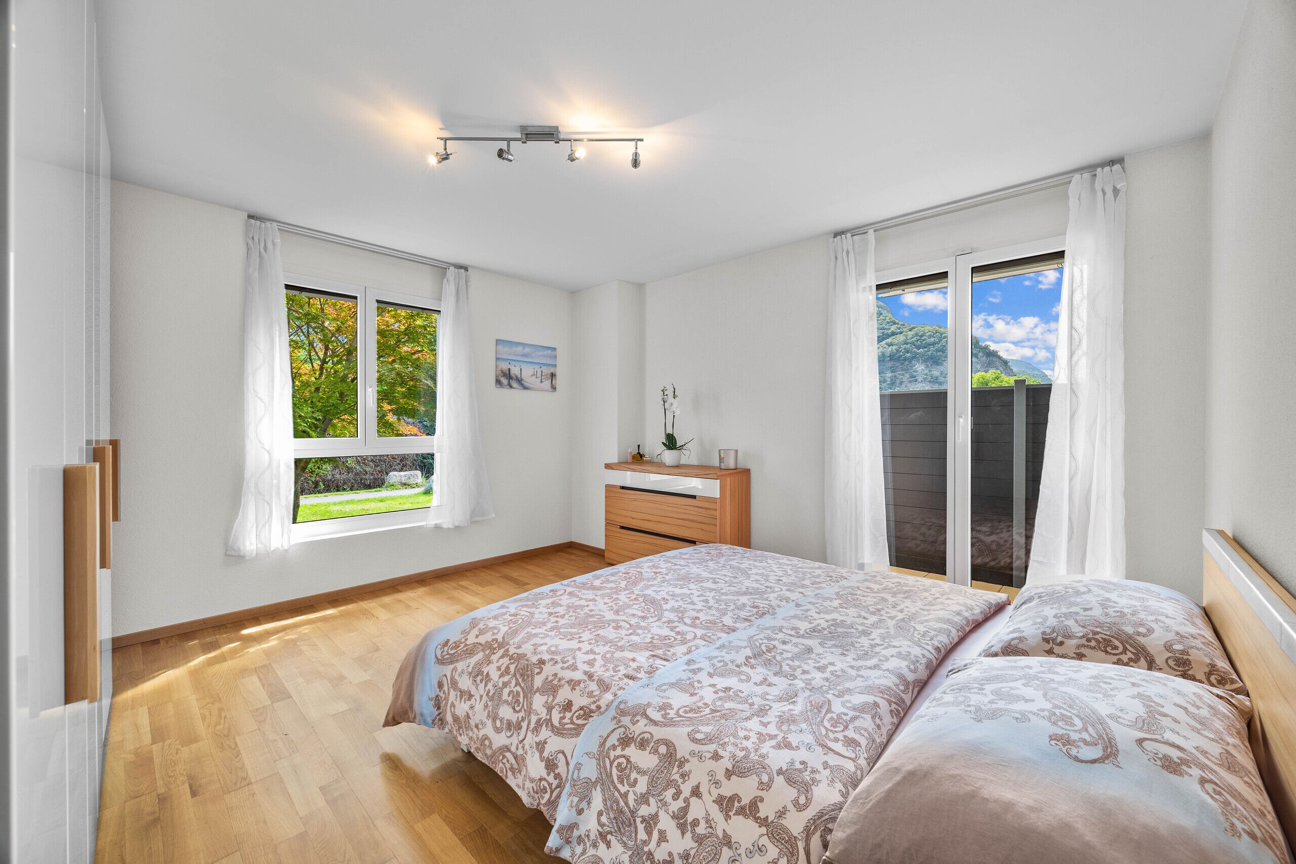 Helles Schlafzimmer mit Balkon und Bergblick