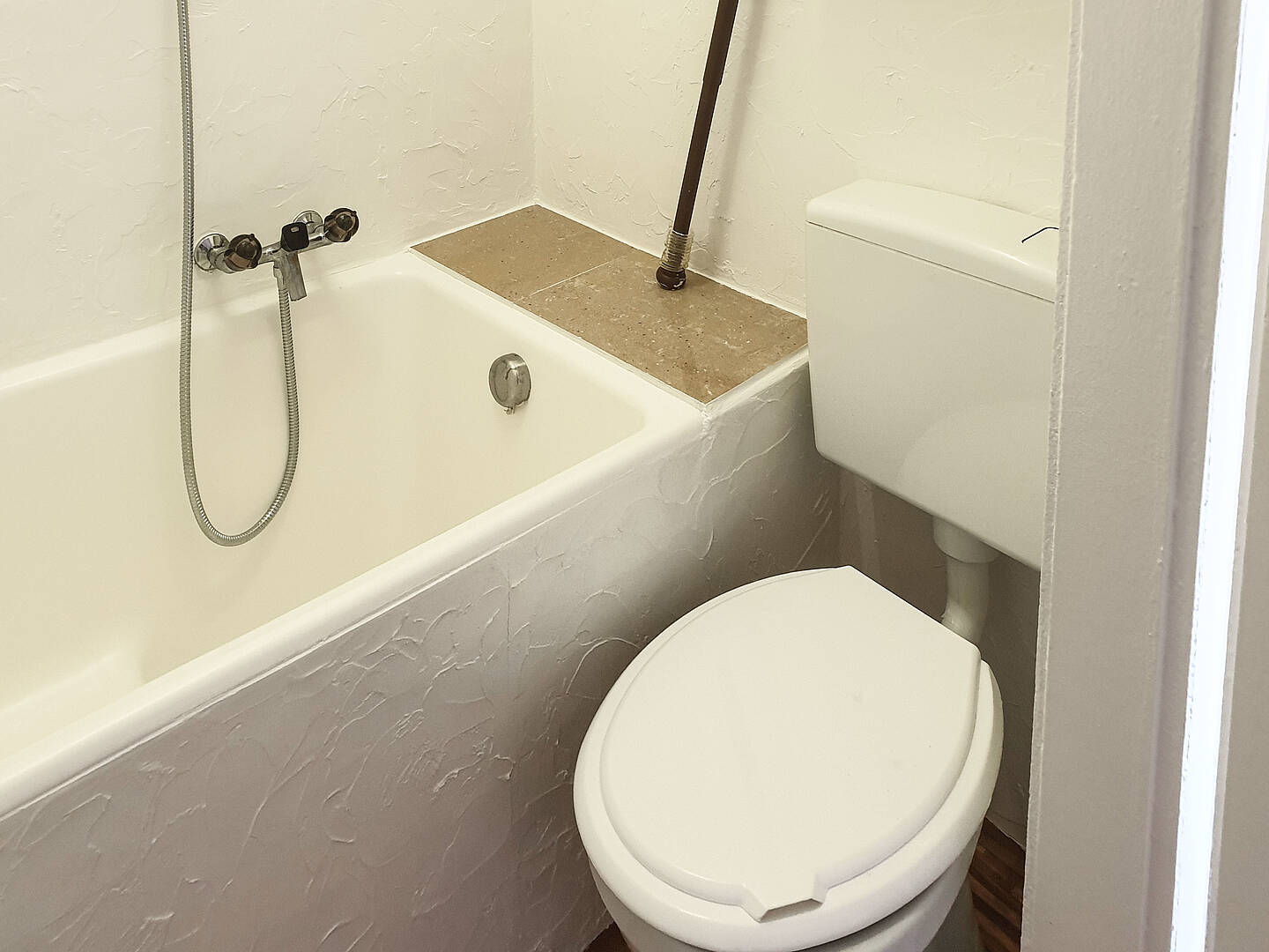 Kleines Badezimmer mit Badewanne und WC