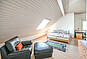 Helles Dachgeschoss-Wohnzimmer mit Sofa und Bett