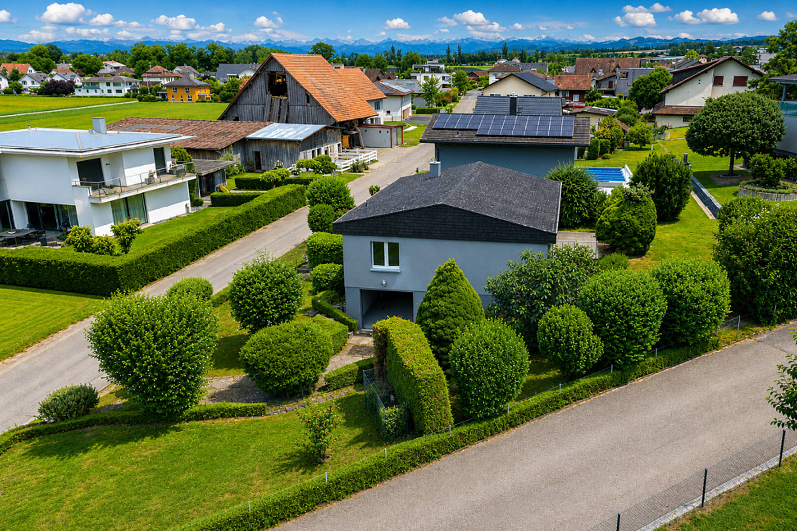 Luftaufnahme eines Wohngebiets mit Einfamilienhäusern und Gärten