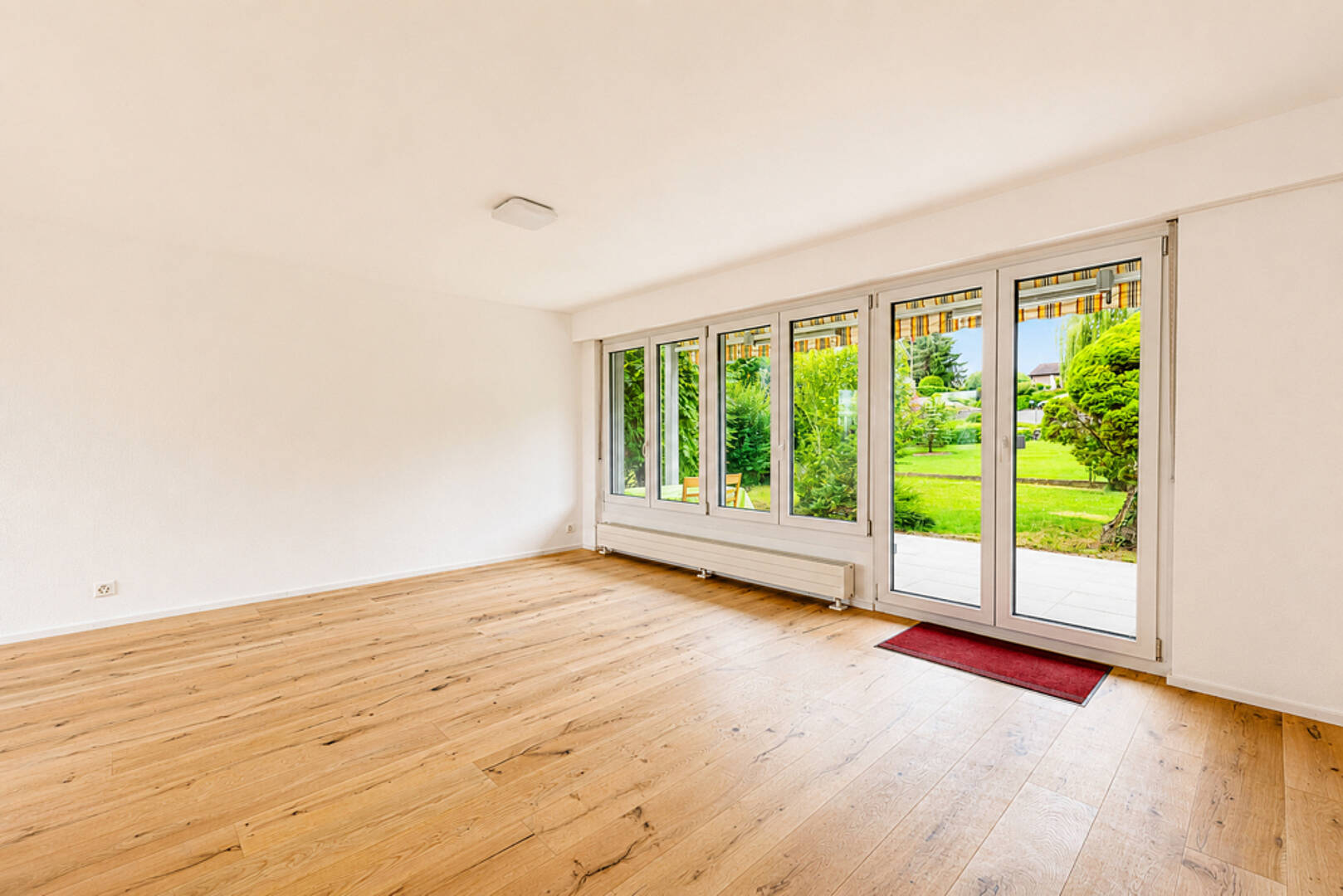 Heller leerer Wohnraum mit Terrassentüren