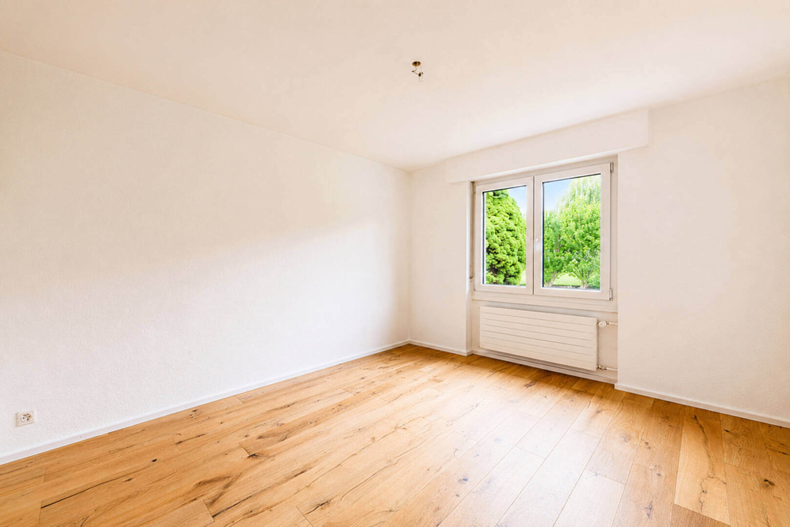 Leeres, helles Zimmer mit Parkettboden