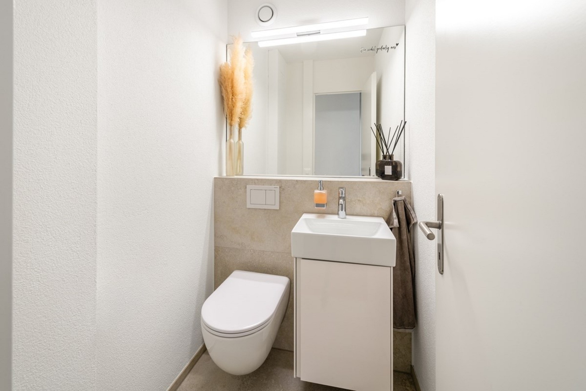 Kleines Gäste-WC mit Waschbecken und Spiegel