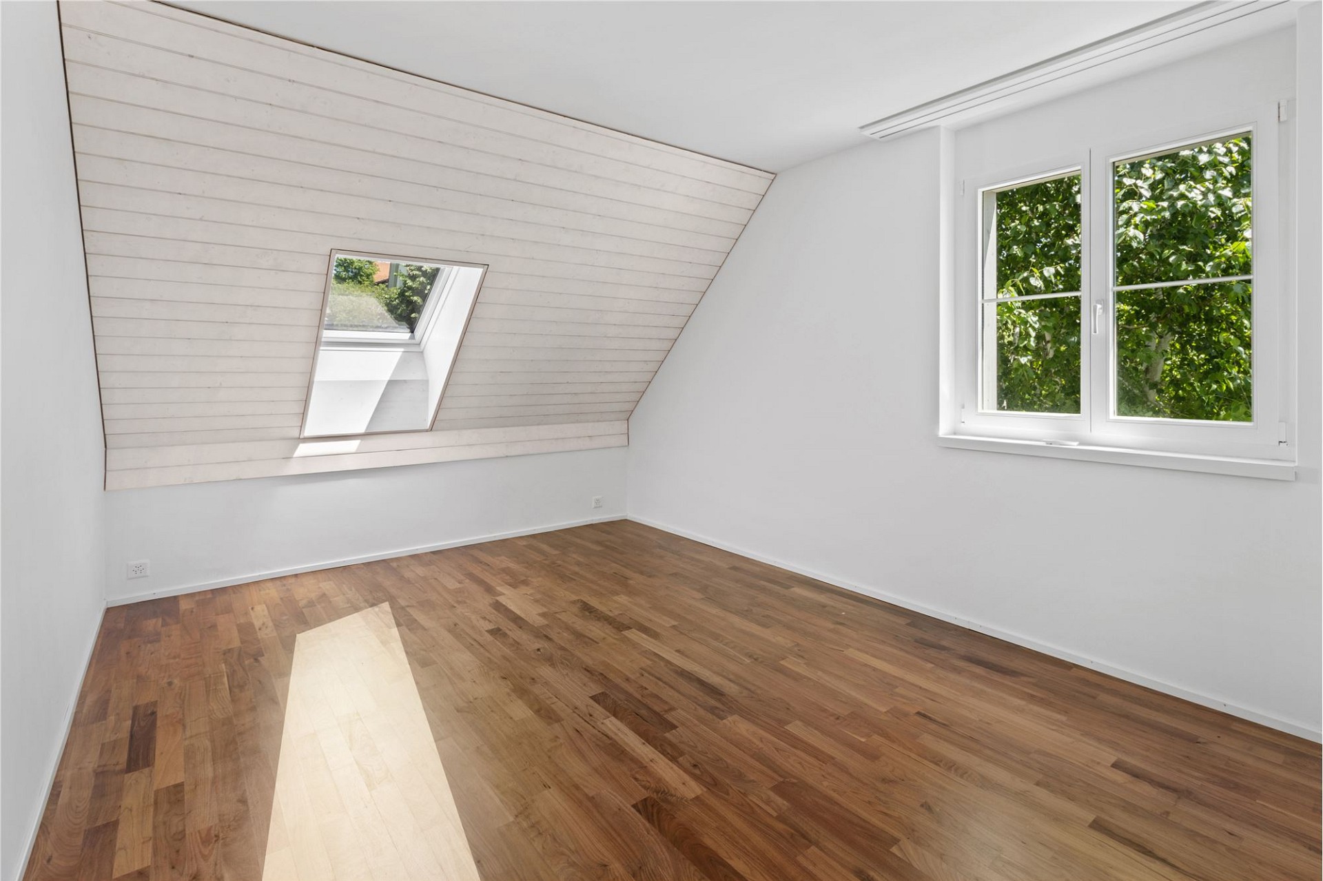 Helles Dachzimmer mit Holzfußboden
