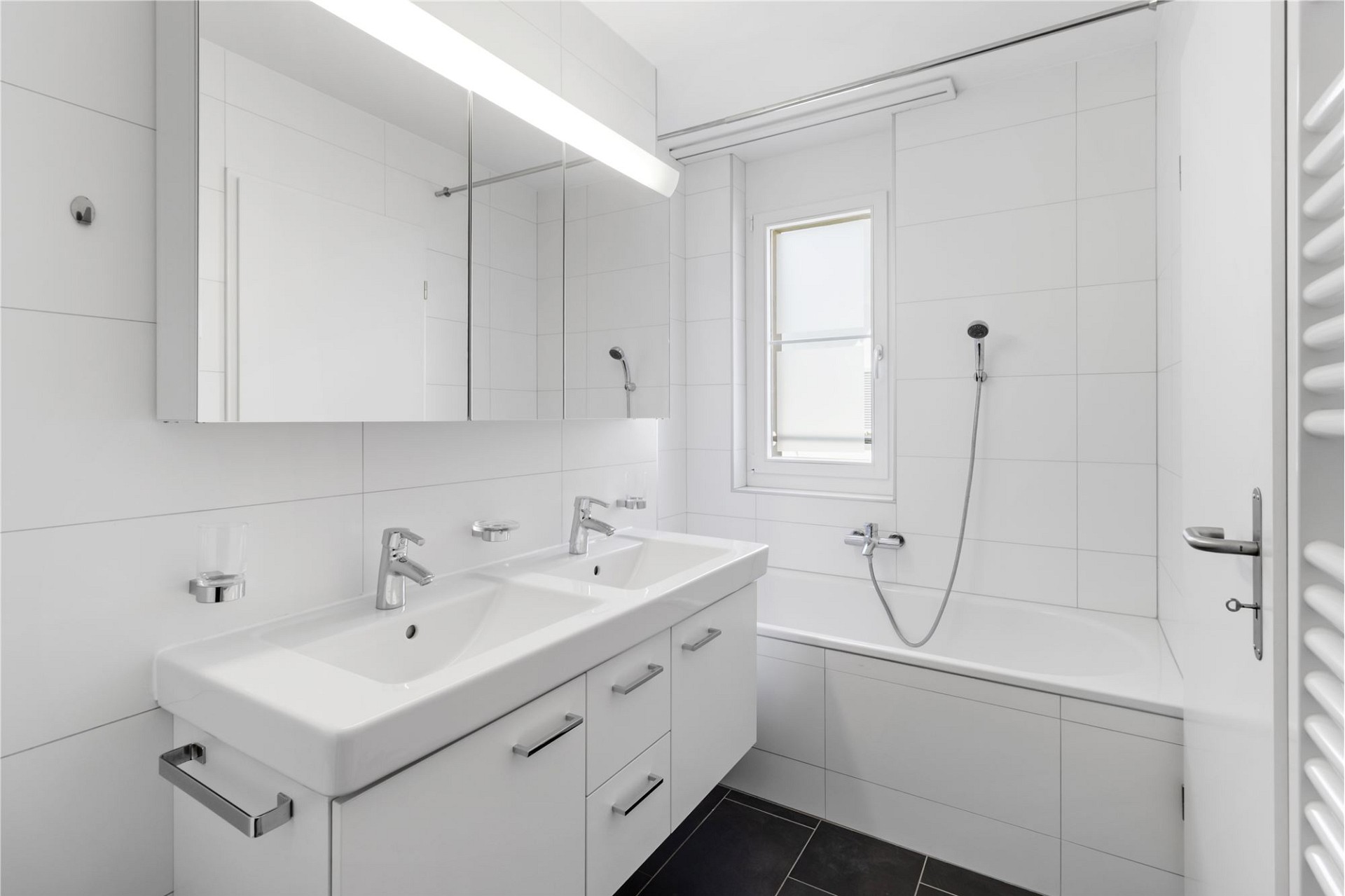 Helles modernes Badezimmer mit Doppelwaschtisch und Badewanne