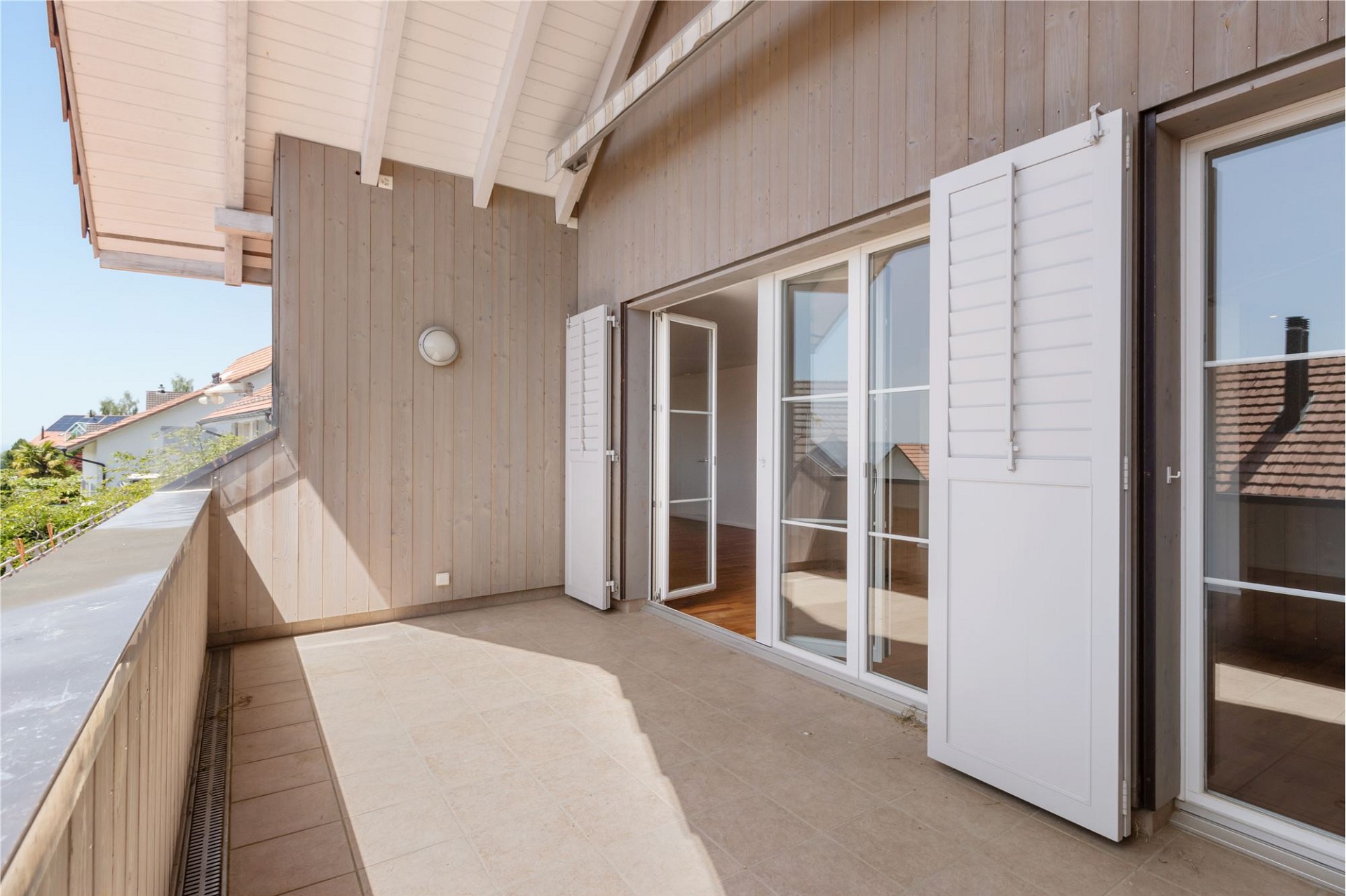 Balkon mit Holzwand und Schiebetüren